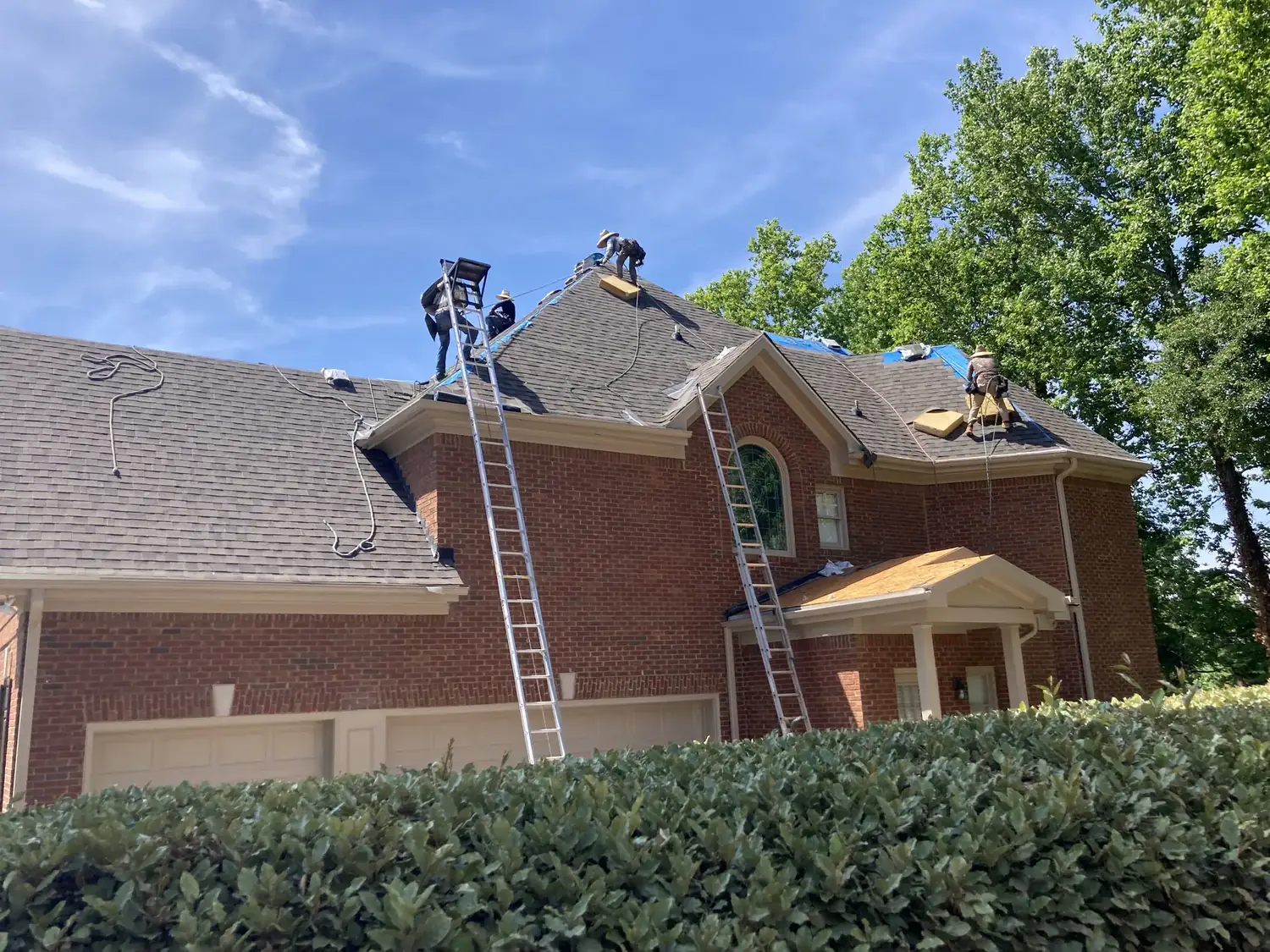 Roofers working on a brick home
